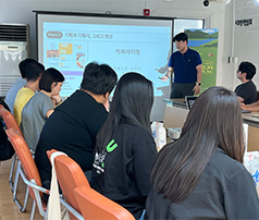 한 남성이 '카피라이팅'이라는 제목의 프레젠테이션 화면 앞에서 앉아 있는 참여자들을 대상으로 강의를 진행하는 모습