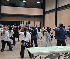 넓은 실내 연습실에서 많은 청소년이 거울을 보며 강사의 동작에 맞춰 단체로 안무 연습이나 댄스 교육을 받는 뒷모습