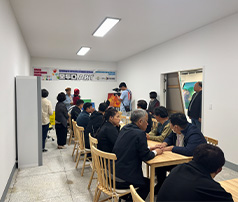 '모두다 ART' 현수막이 걸린 실내 교육장에서 성인 참여자들이 테이블에 마주 앉아 대화하거나 작업을 하고, 한쪽에서 영상 촬영이 진행되는 모습